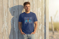 A man in a blue unisex heavy cotton tee with an ocean air and salty hair graphic print.