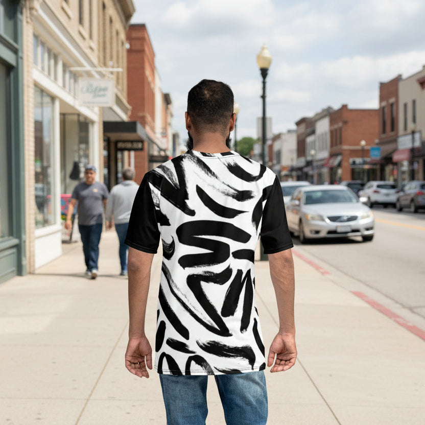 Man walking on a sidewalk wearing a black and white patterned shirt.