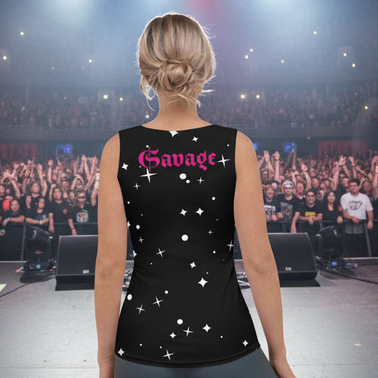 Person on stage wearing a black sleeveless shirt with 'Savage' printed on it, facing an audience.